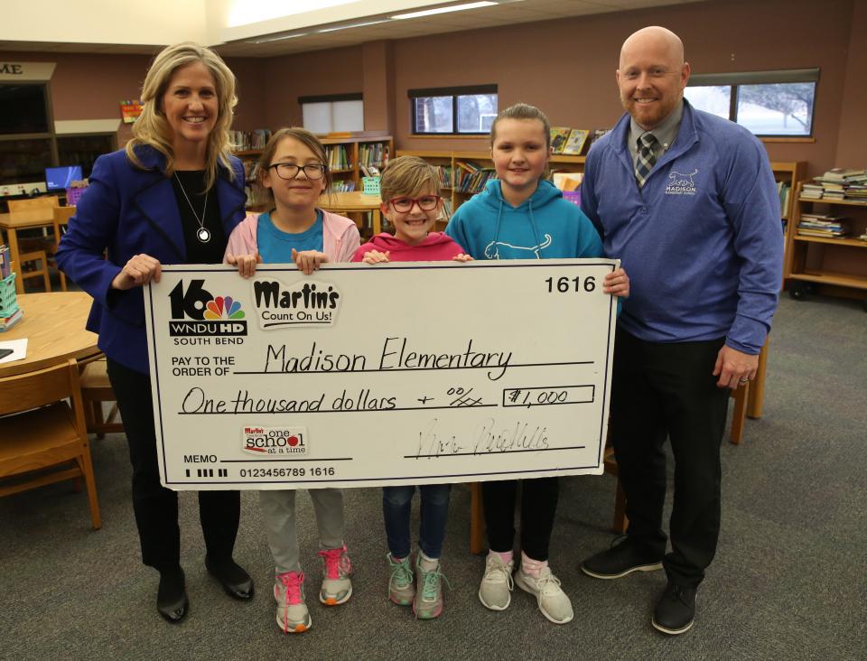 WNDU's Tricia Sloma (left) presenting their check with Madison Elementary School Principal Kevin McMillen (right) and Madison Students