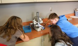 Teacher and students watching fidget tool being printed on 3D printer