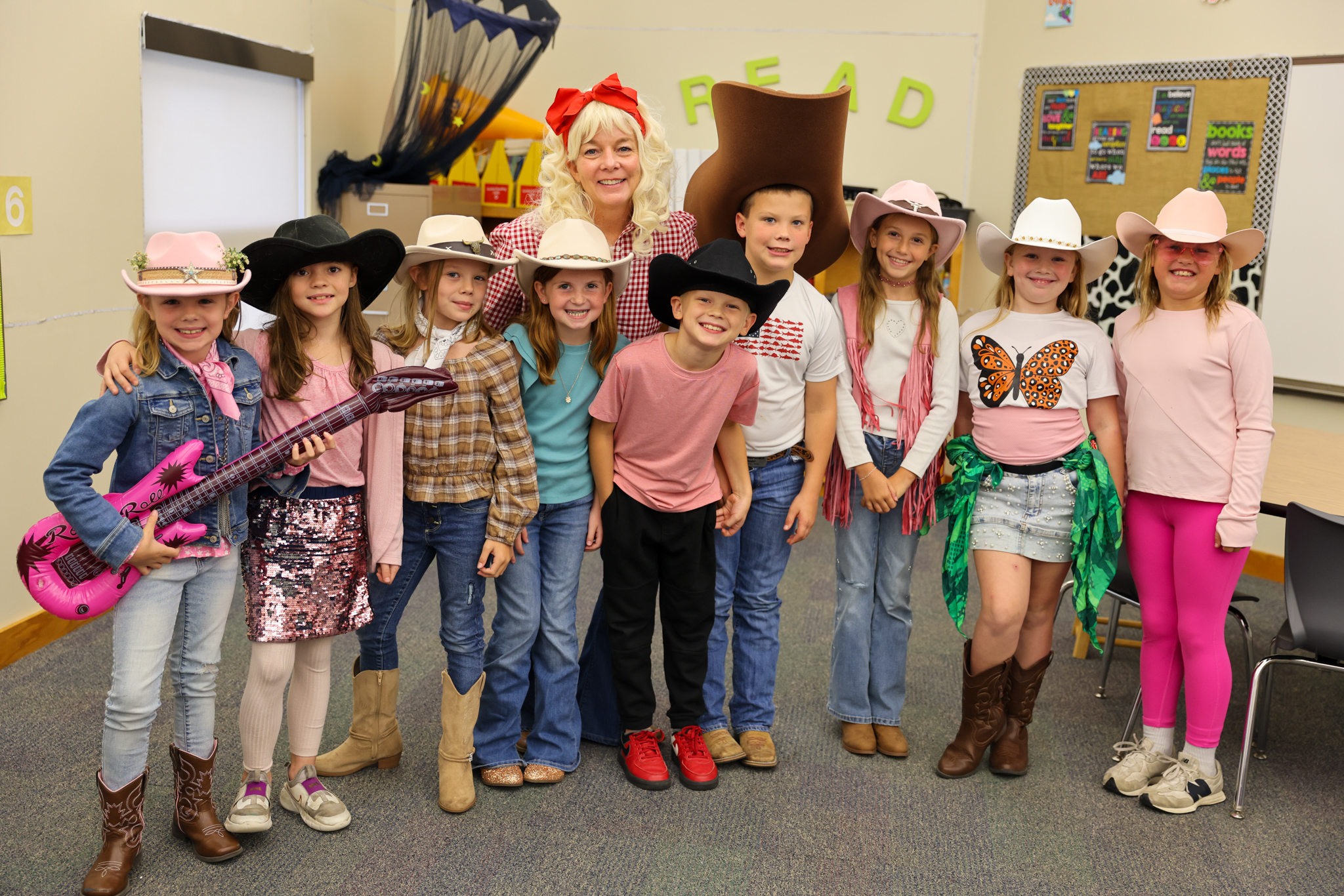 A group of children dressed in cowboy outfits, posing for a photo.